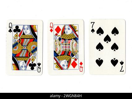 Vintage playing cards showing a pair of queens and a black seven isolated on a white background. Stock Photo