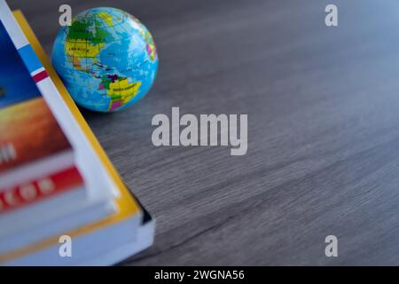Closeup image stack of books with a globe on a wooden table. Copy space for text. World book day, education and knowledge concept. Stock Photo