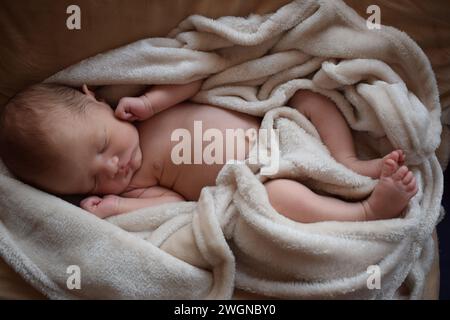 Sound asleep in a busy world, cozy and safe little baby boy Stock Photo