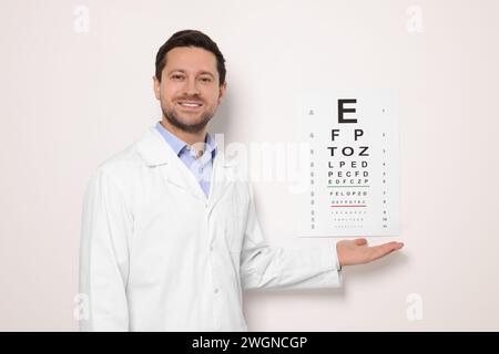 Ophthalmologist showing vision test chart on white wall Stock Photo