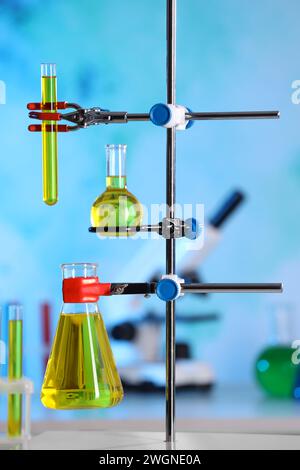 Laboratory glassware with yellow liquid on retort stand indoors Stock Photo