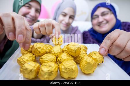 Females having sweets together feeling excited , hospitality concept for muslim females Stock Photo