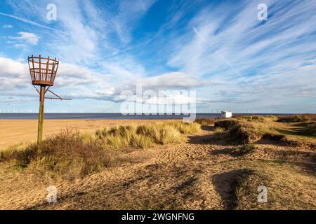 Looking out towards the sea at Skegness in Lincolnshire, with an unlit fire beacon in the foreground Stock Photo