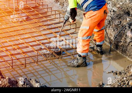 Builder using electric breaker fot breaking concrete from the top of pile to fit reinforcement cage on top of it Stock Photo