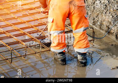 Builder using electric braker fot breaking concrete from the top of pile to fit reinforcement cage on top of it Stock Photo