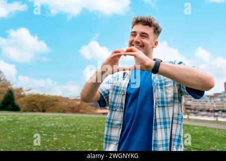 a young man with heart-shaped hands in the park  summer day Fall in Love concept Stock Photo