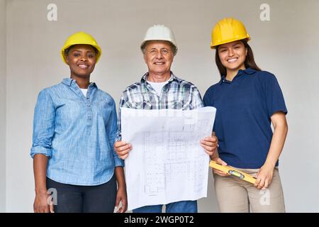 Construction workers standing with blueprint design Stock Photo