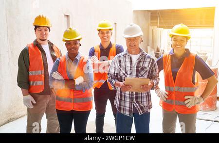 Multiracial group of construction workers on site with architect working on new house Stock Photo