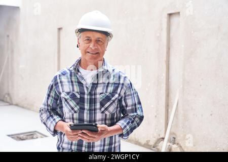 Smiling senior male contractor with tablet PC Stock Photo