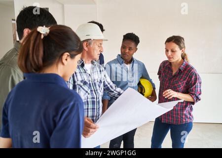 Coworkers and contractor meeting over blueprint Stock Photo