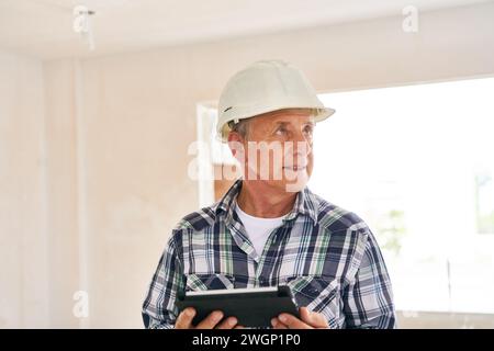 Architect wearing hardhat holding tablet PC Stock Photo