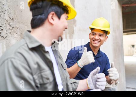 Happy mason coworkers showing thumbs up Stock Photo