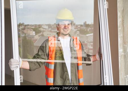 Smiling young male worker carrying window frame Stock Photo