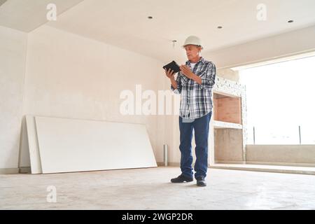 Architect wearing hardhat using tablet PC Stock Photo