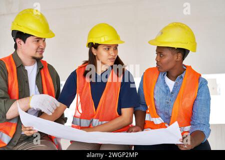 Diverse workers discussing while examining blueprint Stock Photo