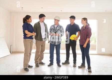 Contractor holding tablet PC discussing with team Stock Photo