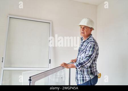 Senior male supervisor standing with window frame Stock Photo