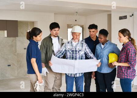 Contractor meeting over blueprint with coworkers Stock Photo
