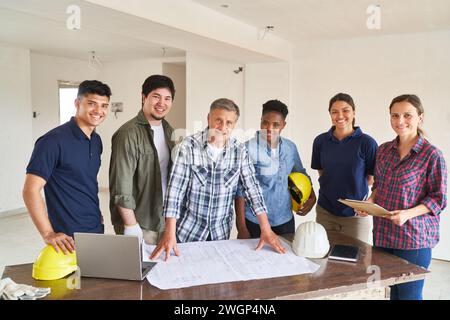 Smiling workers and architect with blueprint Stock Photo