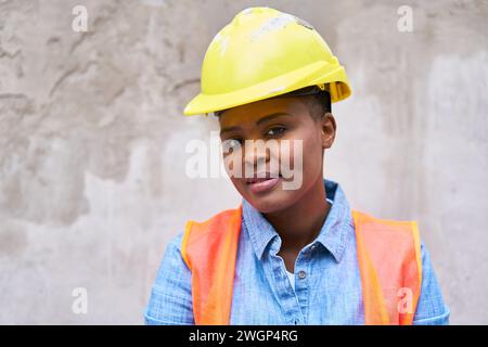 Confident young female mason wearing hardhat Stock Photo