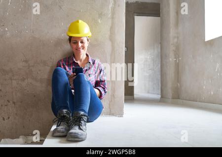 Smiling female worker using smart phone Stock Photo