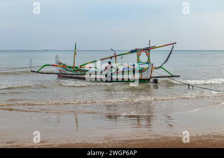 Asian fishermen prepare to work on traditional fishing boats floating on the coast of Sumenep, Madura island, Indonesia. Stock Photo