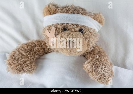 Injured Teddy Bear wrapped in bandages Stock Photo