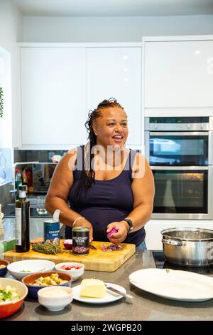 A woman prepares food in her modern kitchen Stock Photo