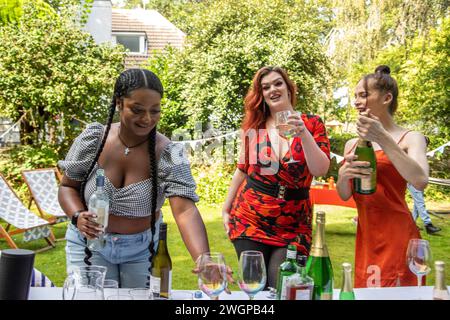 Mixed group of female friends and family gathering to have fun and  enjoy a summer BBQ garden party . Stock Photo
