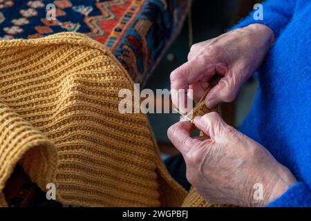 Close up of an Elderley lady knitting at her dining room table Stock Photo