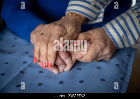two elderly ladies holding hands close up Stock Photo