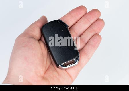 Modern car key in hand palm macro close up view isolated Stock Photo