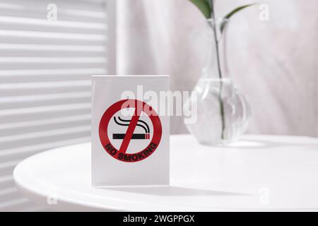 No Smoking sign on white table indoors, space for text Stock Photo