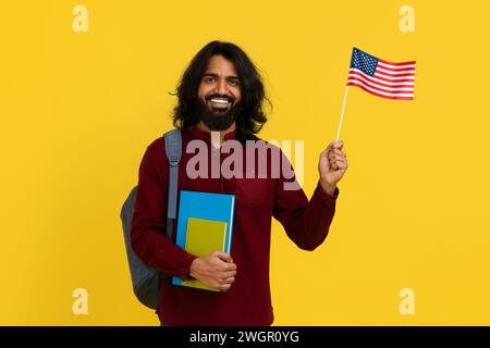 Smiling indian guy student with backpack and bunch of books Stock Photo
