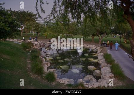 Katara's North and South Hills in Doha, Qatar sunset shot showing abundance of greenery, purple running paths, and water features Stock Photo