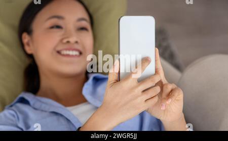 Top view of relaxed asian woman using smartphone Stock Photo