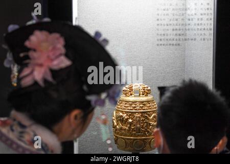 (240206) -- BEIJING, Feb. 6, 2024 (Xinhua) -- Visitors look at a chime bell in the Palace Museum in Beijing, capital of China, Jan. 28, 2024.  First created in the Yuan Dynasty (1271-1368), the Beijing Central Axis, or Zhongzhouxian, stretches 7.8 kilometers between the Yongding Gate in the south of the city and the Drum Tower and Bell Tower in the north. Gates, palaces, temples, squares and gardens of the old city are all linked up to the axis.    As the Spring Festival of the Year of the Dragon approaches, many festive elements with the theme of 'dragon' have been spotted at the axis of Beij Stock Photo