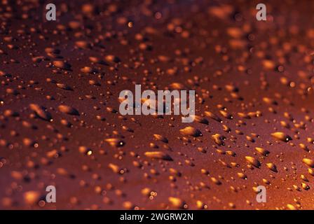 Drops of water on a red metal surface. Abstract red water drops background. Stock Photo