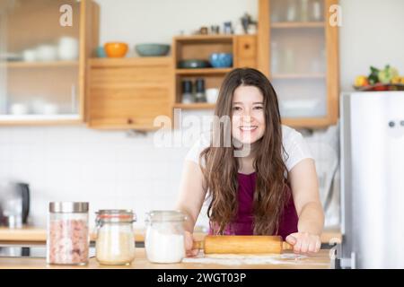 young woman making a pizza in a kitchen Stock Photo