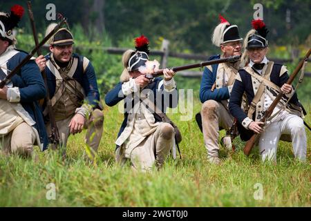 Historical re-enactors act out a revolutionary war battle between the British Red Coats and American rebels at Old Sturbridge Village in Sturbridge, M Stock Photo