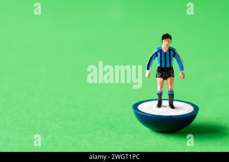 A single Subbuteo miniature figure painted in the Inter Milan home team colours of blue and black striped shirts and black shorts Stock Photo