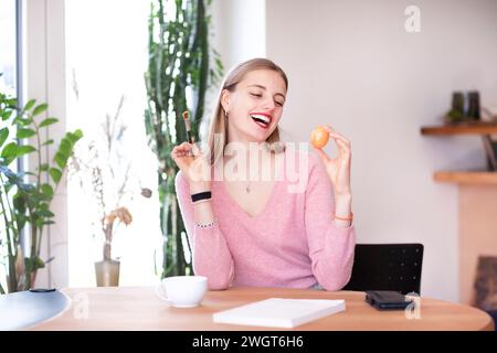young woman with blond hair practices make-up with an egg Stock Photo