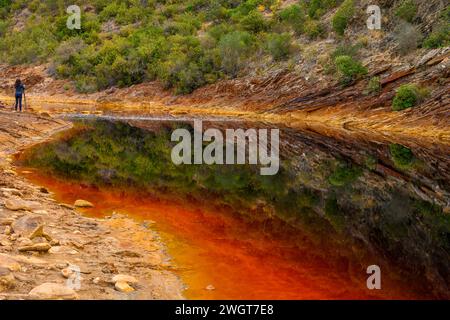 Striking layers of earth and a vivid streak of red water line the cracked ground of the Rio Tinto Stock Photo