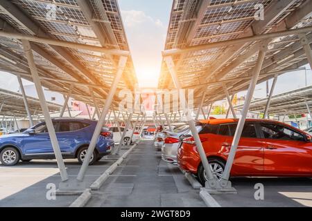 Solar panels installed over parking lot with parked cars for effective generation of clean energy. Stock Photo