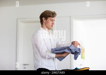 Young man packs suitcases at home Stock Photo