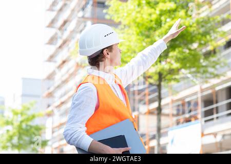 Engineer with helmet working outside new building Stock Photo