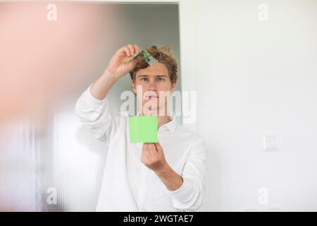 Young man building a green energy house model Stock Photo