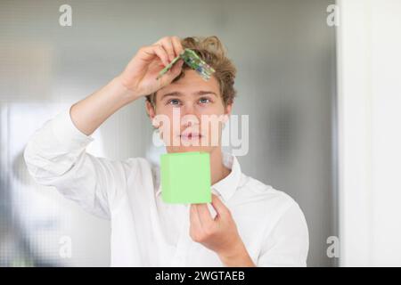 Young man building a green energy house model Stock Photo