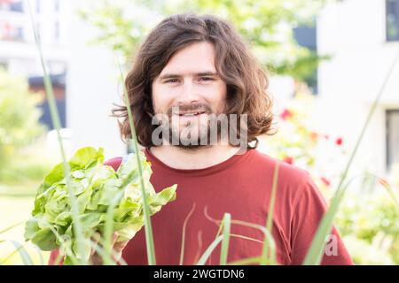young man with a salad standing in the garden in the city Stock Photo