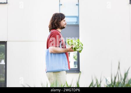 young man with a bag selling a salad and walking home in the city Stock Photo